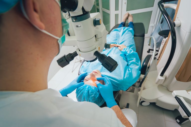 Eye surgery. A patient and surgeon in the operating room during ophthalmic surgery. Patient under surgical microscope. Vision correction